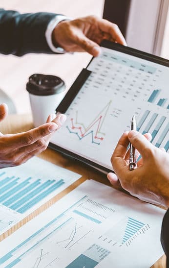 Hands holding a tablet with charts